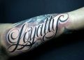 Loyalty Tattoo Writing on Upper Arm